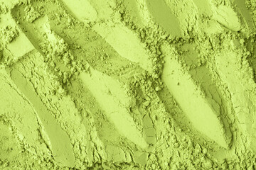 Fine matcha green tea powder creates abstract textured pattern with soft shadows, evoking natural organic surface for versatile design use.