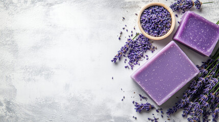 Top view of lavender soap bars with blossoms on textured surface with empty space. Aromatic spa decor, hobby and wellness theme