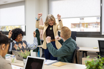 Diverse business team celebrating success in modern office