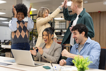 Diverse business team celebrating success at office