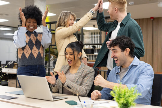 Diverse business team celebrating success at office