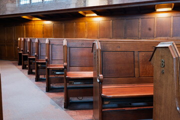 Empty, wooden church pews or benches inside protestant church, no people