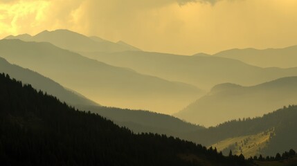 Obraz premium Serene Mountain Landscape with Layers of Fog and Light Filtered Through Clouds at Sunrise, Capturing Nature's Tranquility and Beauty in Soft Hues