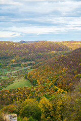 Germany, Aerial view above colorful autumn forest from castle hill above nature landscape mountains and valleys view to castle teck ruins