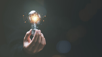 solution concept and demonstrating leadership strategies ,ideas ,thought process ,innovation and brain power from brainstorming ,A light bulb representing the power of thought in the human hand