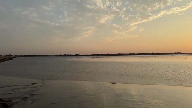 Serene Sunset Over Calm Waters with Golden Reflections