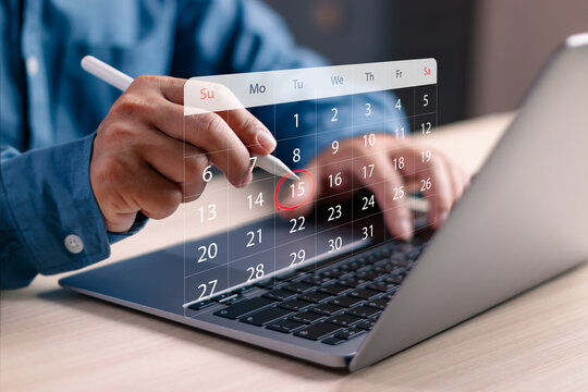 Closeup of hands using stylus on a digital calendar over a laptop, highlighting a specific date. Concept of online scheduling, appointment setting, planning, time management and productivity