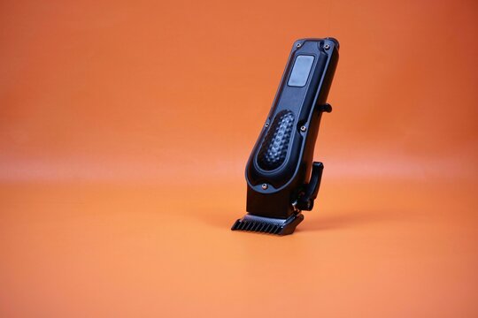 Professional Hair Clipper With Adjustable Blade Standing On Orange Background - Powered by Adobe
