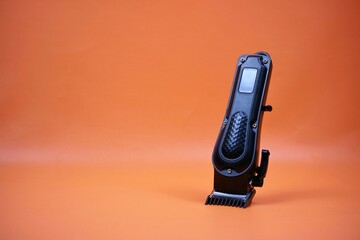 Professional Hair Clipper With Adjustable Blade Standing On Orange Background