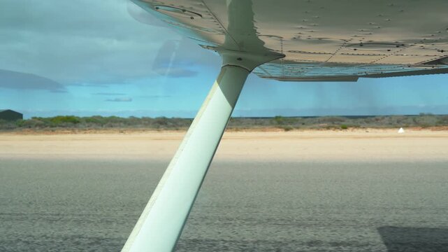 Scenic view of small plane taking off from dusty outback runway in Western Australia