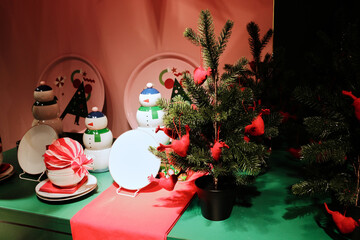 Holiday table decorated with small Christmas trees, snowman figures, and colorful dishes. Symbolizes celebration, family warmth, and cheerful design
