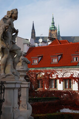 Historic stone statue in autumn garden with ivy-covered wall