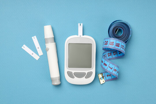 Blood glucose meter and strips on a blue surface