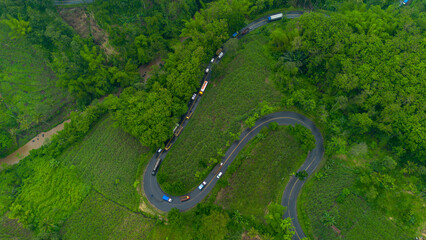 Aerial view of winding road in Malang, East Java, Indonesia surrounded by tropical green hills