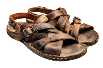 A pair of old worn leather sandals with buckles on a black background