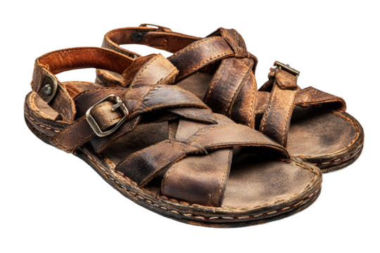 A pair of old worn leather sandals with buckles on a black background
