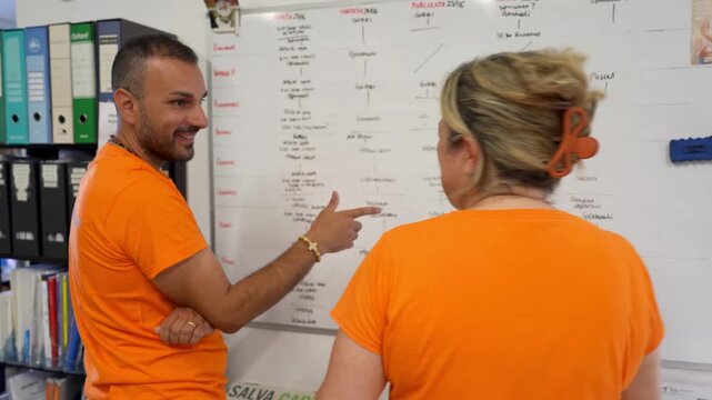 Young staff analyzing daily shifts and intervention plans on the company noticeboard