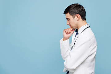 Side profile view young minded pensive male doctor man wear white medical gown suit work in hospital clinic office think isolated on plain blue background studio portrait. Healthcare medicine concept