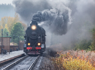 Steam retro train arrives to the station platform.