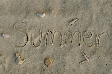 Word SUMMER Written in Sand with Shells and Coral