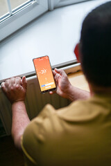 Smartphone connecting to heating system. Remote home control system on a smartphone. smart home