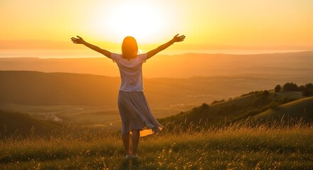 Fototapeta premium Woman with arms outstretched embracing the sunrise from a hilltop