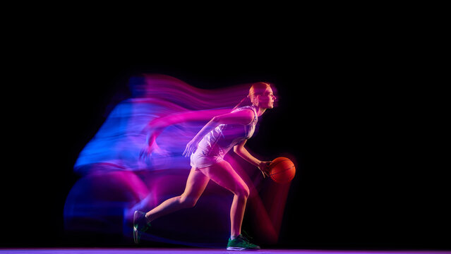 Female basketball player running with ball in neon motion blur. Concept of sports marketing, fitness ads, energy campaigns, and motion design visuals. - Powered by Adobe