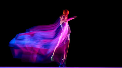 Basketball player jumping with glowing ball and neon motion trails. Concept of success, athletic progress, sports branding, energy design, and motivational advertising visuals.