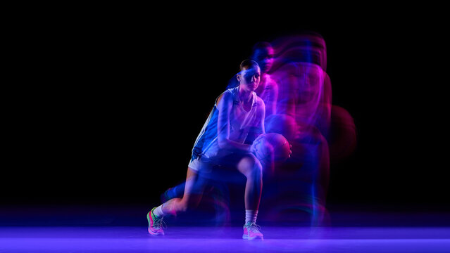 Female basketball player training under neon motion lights. Concept of sports coaching visuals, athletic training guides, performance improvement ads, and activewear promotion.