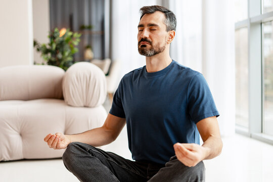 Man meditating at home finding inner balance