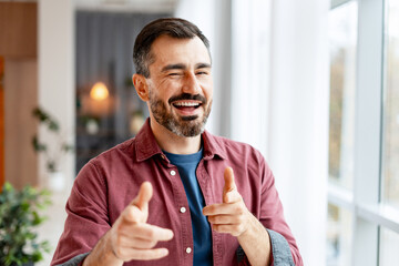 Mature man winking and pointing at camera