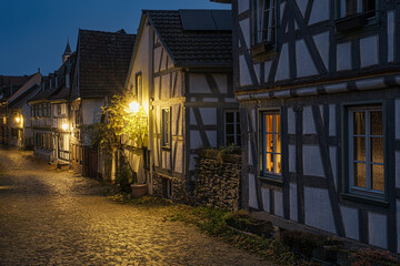 A small, romantic alley in the old town of Idstein in the Taunus region of Hesse, illuminated by streetlights in the evening.