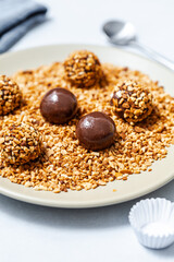 Brazilian brigadeiro candies being rolled in crushed peanuts