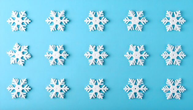A minimal flat lay pattern of white decorative snowflakes arranged on a vibrant blue background. Ideal for winter, Christmas, and seasonal design.