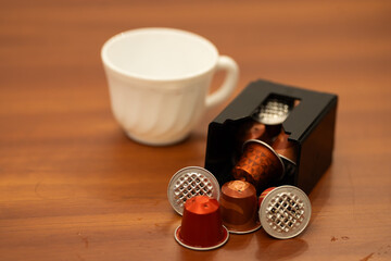Close-up of a coffee capsule container for an espresso machine, designed to collect used coffee pods. The plastic bin is part of the espresso maker system, showing details of the compartment where use