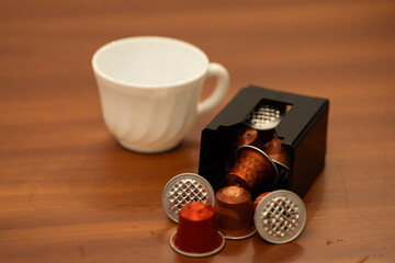 Close-up of a coffee capsule container for an espresso machine, designed to collect used coffee pods. The plastic bin is part of the espresso maker system, showing details of the compartment where use
