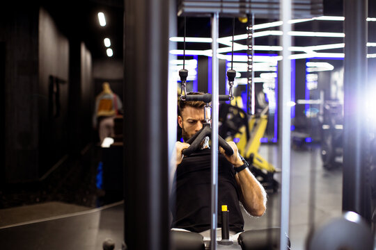 Fitness enthusiast focusing on strength training in a modern gym setting