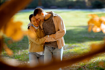 Happy couple enjoying a sunny day in the park during autumn season