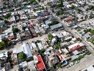 Aerial top-down view high altitude of slum a heavily populated urban informal settlement characterized by substandard housing and squalor poor living conditions streets and rusty metal home roof tops