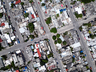 Aerial top-down view high altitude of slum a heavily populated urban informal settlement characterized by substandard housing and squalor poor living conditions streets and rusty metal home roof tops