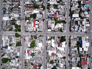 Aerial top-down view high altitude of slum a heavily populated urban informal settlement characterized by substandard housing and squalor poor living conditions streets and rusty metal home roof tops