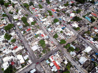 Aerial top-down view high altitude of slum a heavily populated urban informal settlement characterized by substandard housing and squalor poor living conditions streets and rusty metal home roof tops