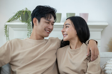 Happy couple laughing on the sofa and watching TV drama online