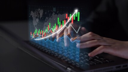 A close-up view of hands typing on a laptop keyboard with a digital stock market graph overlay, representing finance analysis, data visualization, and investment strategies. Copula