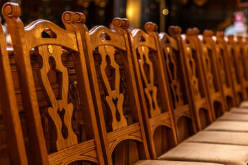 Patterned church chair backs in golden light. Warm texture.