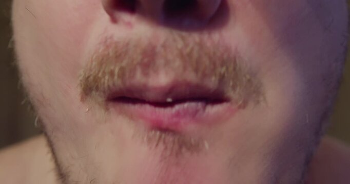 Close up of man mouth biting and chewing bread with bacon slice, displaying strong appetite and enjoyment.