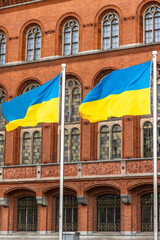 Two Ukrainian flags in the wind near historic facade. Symbol of freedom.