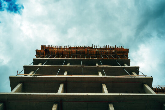 Low angle view of modern corporate office building construction site, concrete frame structure with scaffolding - Powered by Adobe