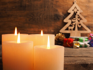 Fourth Advent candles burning with Christmas decoration on a wooden background