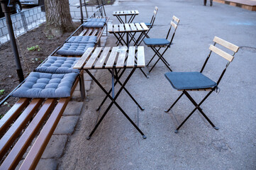 Outdoor seating area with tables and chairs in a row.